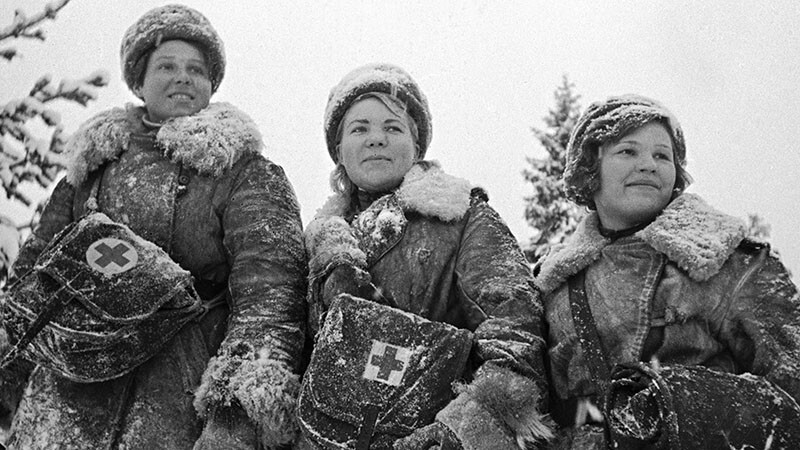 Три женщины-санинструктора стоят, готовые к несению службы.