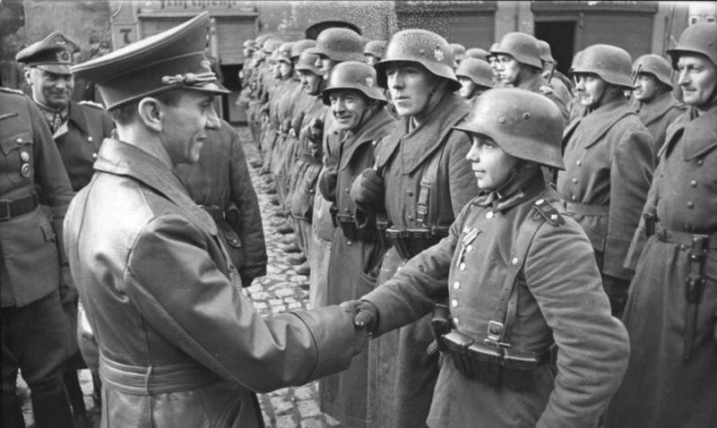Йозеф Геббельс (Joseph Goebbels) поздравляет 16-летнего солдата Вильгельма Хюбнера (Wilhelm Hübner) после награждения его Железным крестом 2 класса. Город Любань (Lauban), ныне в Польше.