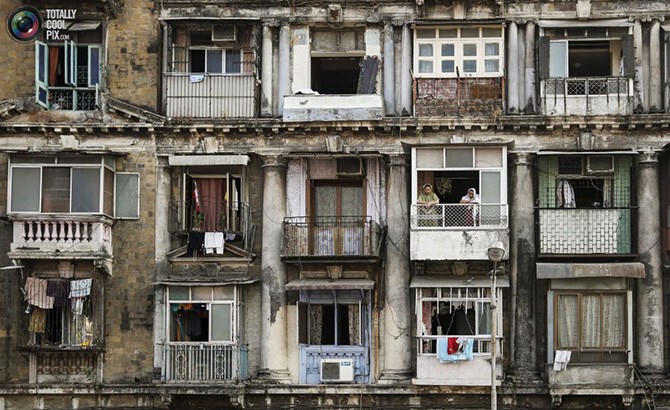 Женщины стоят на балконе квартиры в южной части Мумбаи