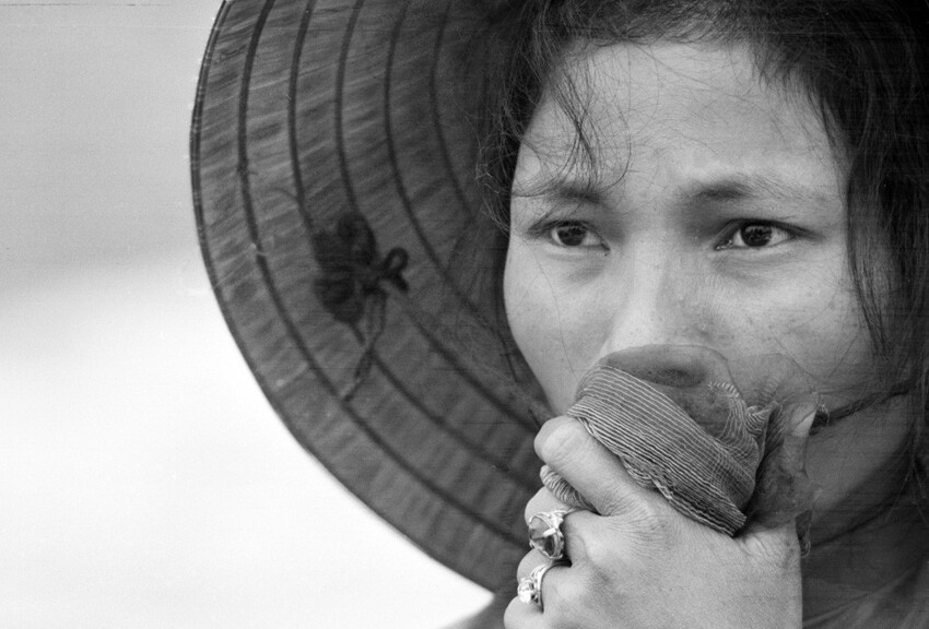 Молодая южновьетнамская женщина прикрывает рот, когда она смотрит в братскую могилу, где жертвами резни стали сотни людей. Апрель 1969 года.
