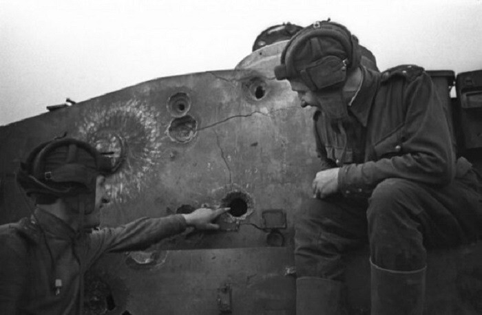 Командир танка лейтенант Б. Смелов показывает пробоину в башне немецкого танка «Тигр», подбитого его же экипажем, лейтенанту Лихнякевичу (фотограф: Н. Боде).