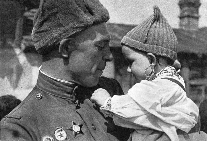 Советский солдат держит на руках чешского ребенка (фотограф: А. Холубова).