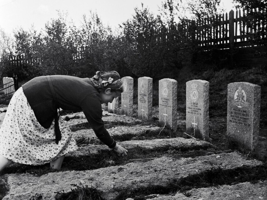 Жительница Мурманска убирает могилу на кладбище американских и английских моряков, погибших во время Великой Отечественной войны