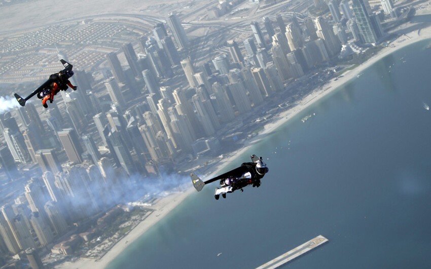 Швейцарский лётчик и авиаизобретатель Ив Росси, более известный под псевдонимом Jetman (справа), и француз Винс Реффетт парят над районом «Jumeirah Beach Residence» в Дубае, ОAЭ.