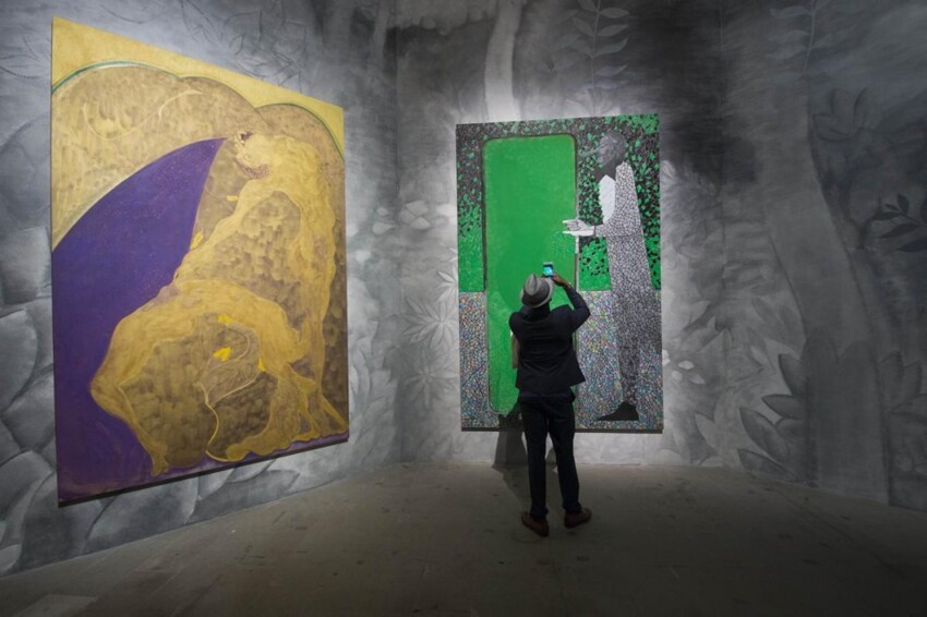 Посетитель фотографирует картину «Зелёное зеркало» («The Green Mirror») британского художника Криса Офили (Chris Ofili) на 56-й Венецианской биеннале