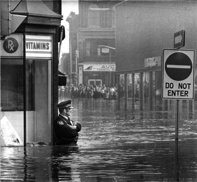 7. Офицер полиции охраняет вход в аптеку во время наводнения в Онтарио, 1974г.
