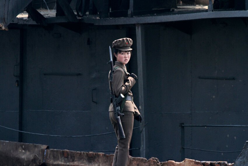 Северокорейский солдат стоит на страже вдоль берега реки Ялу недалеко от северокорейского города Синыйджу, напротив китайского пограничного города Даньдун.