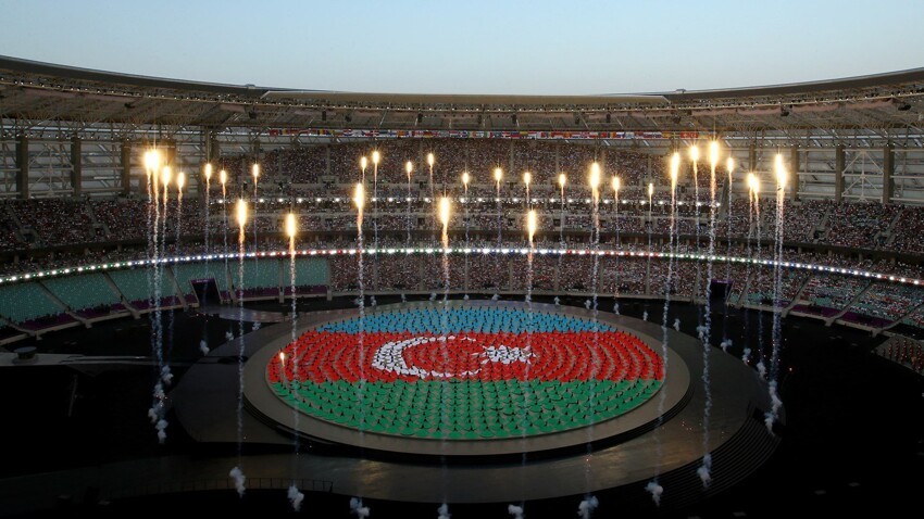 Фейерверки взмывают вверх над изображением флага Азербайджана.
