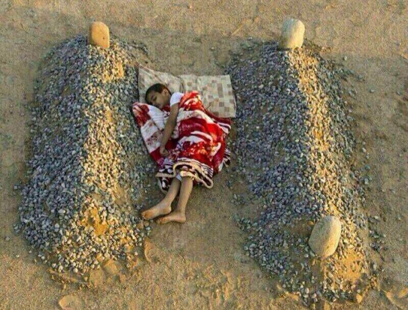 14. "Сирийский мальчик спит на могилах своих родителей" - всего лишь фотосессия