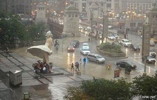 Люди прячутся от дождя под восьмиметровой статуей Мэрилин Монро в Чикаго