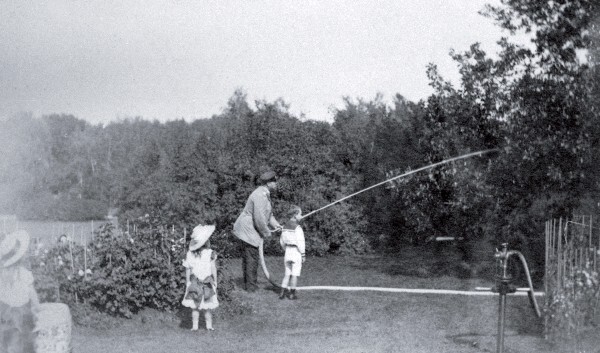 Александр III с детьми поливает деревья в саду. Конец 1880-х гг