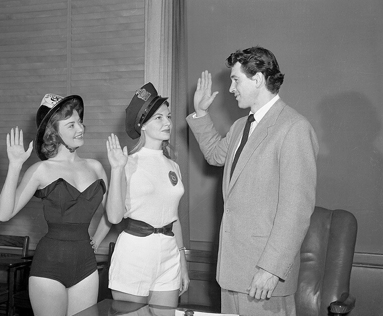 Актер Рок Хадсон приветствует «Мисс США-1952» Джеки Лохири (слева) и актрису Марилин Максвелл (справа)