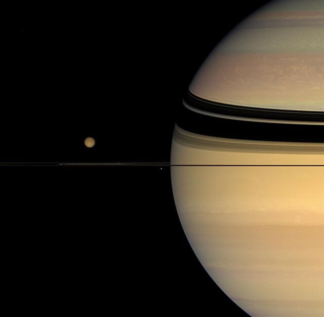Четыре спутника вокруг колец Сатурна.