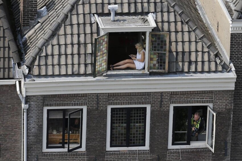 Фотограф (внизу) и болельщица (вверху) ждут, когда покажутся велогонщики, на 2-м этапе «Тур де Франс» на отрезке пути «Утрехт — Нельтье Янс» в Нидерландах