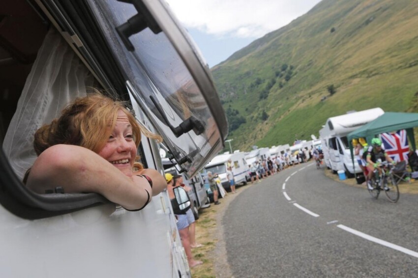 Женщина смотрит 12-й этап велогонки «Тур де Франс» из окна автофургона