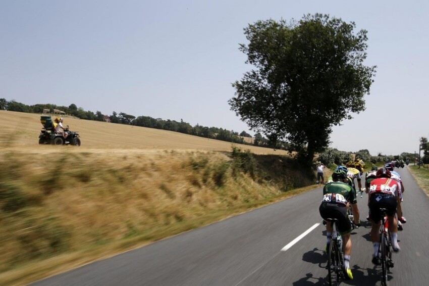 Пелотон велогонщиков едет на 13-м этапе «Тур де Франс» на отрезке пути «Мюре – Родез» во Франции