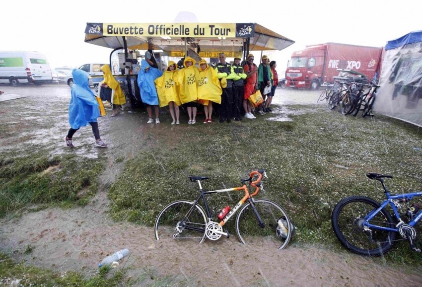 Болельщики прячутся от дождя в ожидании велогонщиков на 12-м этапе «Тур де Франс» во Франции