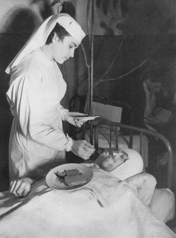 Медсестра Ленинградского Военно-морского госпиталя Анна Юшкевич кормит раненого краснофлотца В.А. Ухова