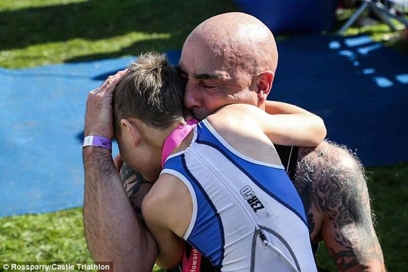 Гордый отец Джонатан Метьюз обнимает своего сына Бэйли, который несмотря на тяжелое заболевание, не только смог финишировать в турнире по триатлону, но и завершил крайние 20 метров без специальных ходунков