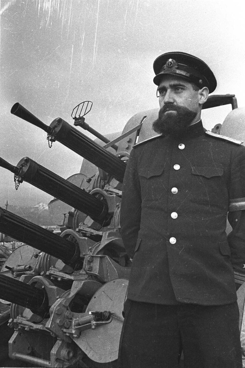 3. Советский вахтенный офицер в звании капитан-лейтенант на фоне 12,7-мм счетверённой корабельной зенитно-пулемётной установки «Виккерс».