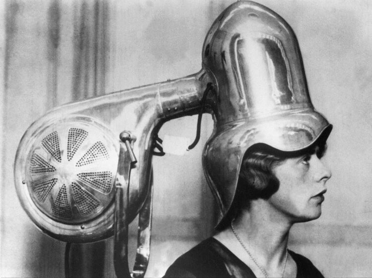 1928 г. Женщина сидит под хромированным феном.