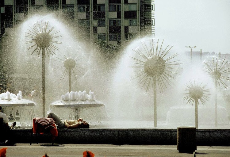 Мужчина отдыхает под фонтаном-одуванчиком в Дрездене