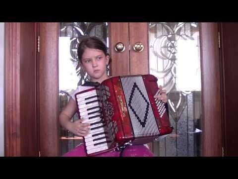 Девочка в восемь лет играет на аккордеоне 