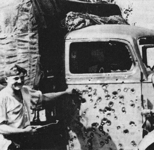 43. Немецкий солдат-шофёр позирует рядом со своим расстрелянным грузовиком