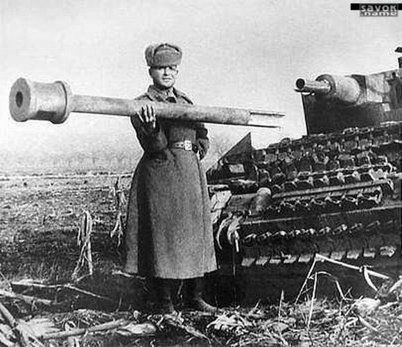 33. Красноармеец держит в одной руке оторванный ствол орудия немецкого танка