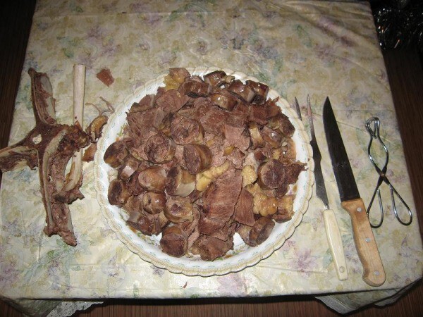 Сварившееся мясо и шужык вытаскиваем, мясо солим и пока горячее отделяем от костей и нарезаем кусками. В мясо нарезаем шужык..
