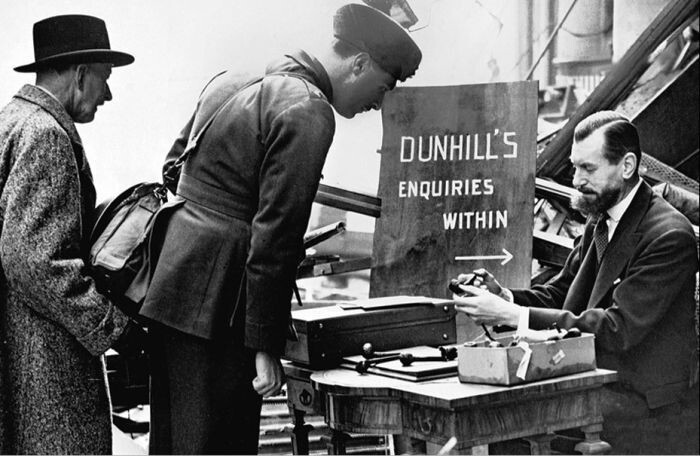  Альфред Данхилл продает трубки на улице перед руинами своего магазина, Лондон, Англия, 1944 год 