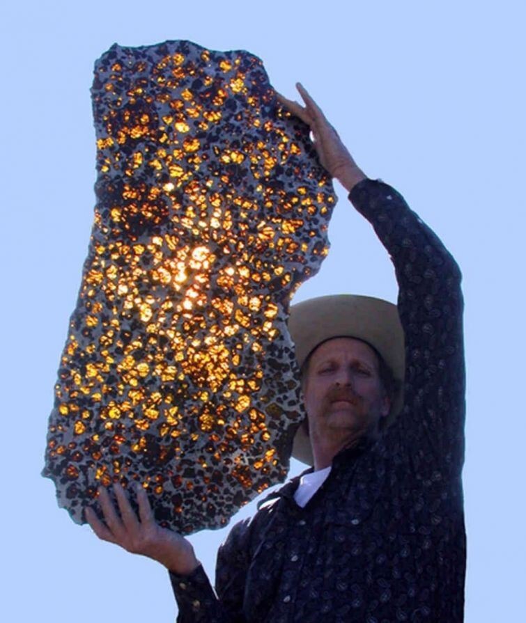 Мужчина держит в руках метеорит Фукан, которому уже 4,5 млрд лет
