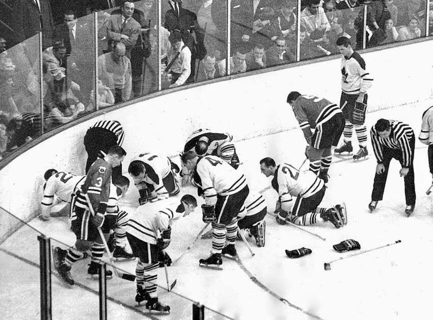 23. Игроки Toronto Maple Leafs и Chicago Black Hawks ищут потерянную дорогую контактную линзу Джека Эванса, 1962 г.