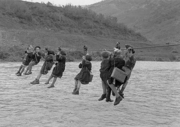 Дети переправляются через реку по дороге в школу на окраине Модены, Италия, 1959