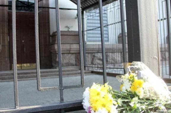 Украинцы несут цветы к российскому посольству в Киеве