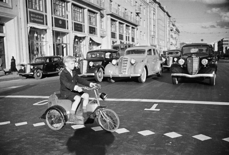  Мальчик на электросипеде (?) пересекает улицу Горького, 1937:
