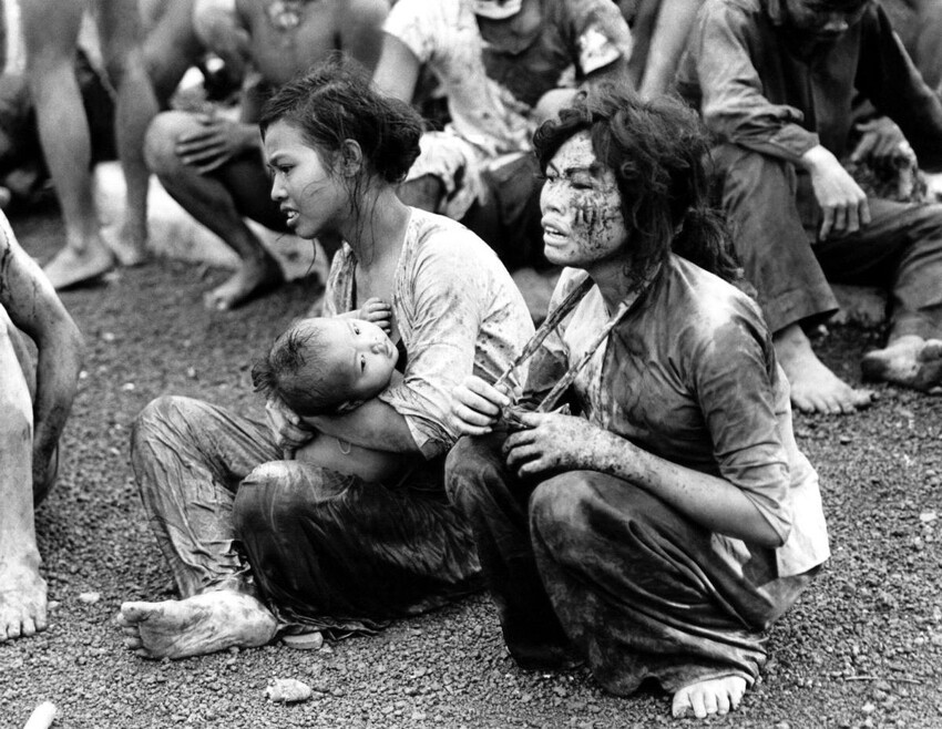 8. Мирные люди, которые вышли из своих подземных укрытий после двухдневной бомбардировки и тяжелых боёв в окрестностях города Донг Хой. Вьетнам, 6 июня 1965 года.