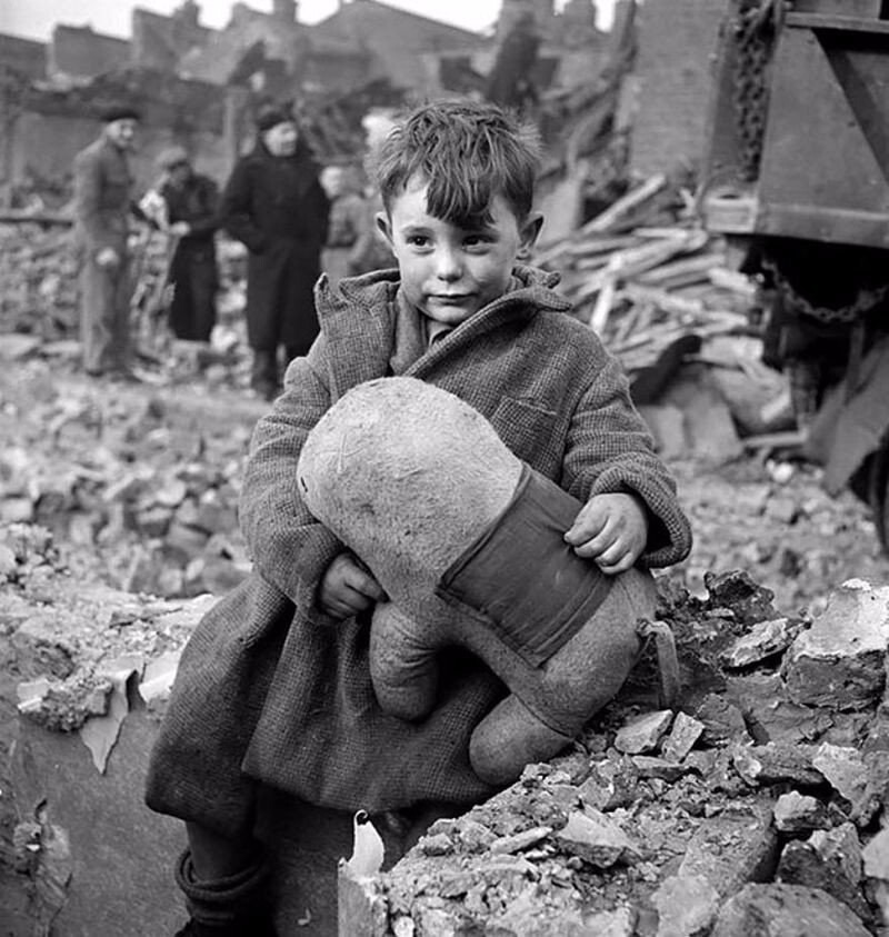 Малыш со своим плюшевым другом на разрушенной улице Лондона, 1945 год