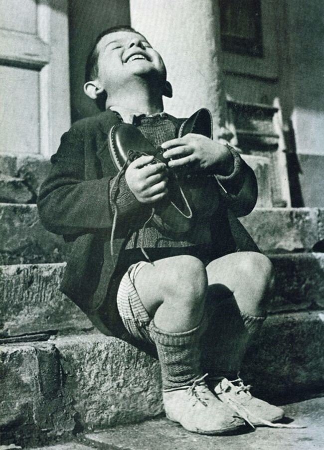 Австрийский мальчик радуется новым ботинкам во время Второй мировой войны
