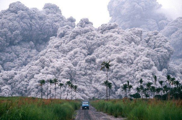 Водитель пикапа пытается сбежать от облака пепла, во время извержения вулкана Пинатубо на Филиппинах, 17 июня 1991 года   