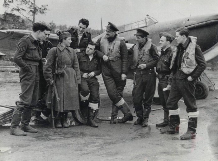 Британские летчики и советский солдат на аэродроме в мурманской области. Осень 1941 года.  