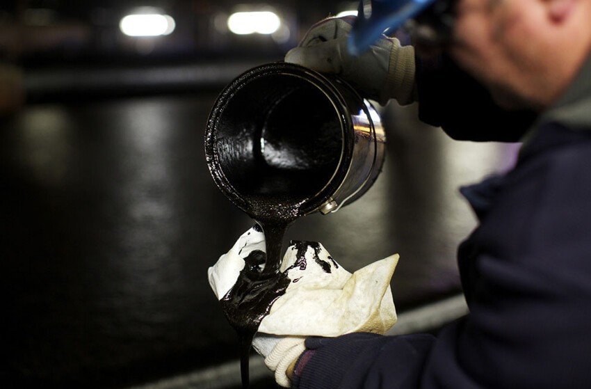 23. Рабочий проверяет нефть, полученную на первом этапе переработки битуминозных песков