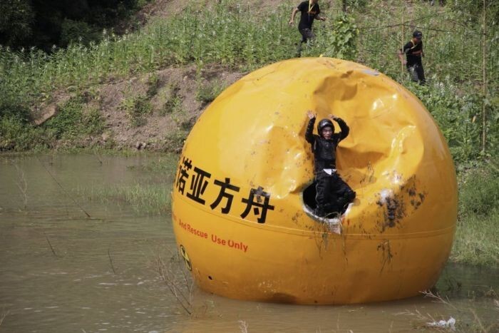 Китайский изобретатель Ян Зонгфу вылезает из собственной спасательной капсулы в 6 тонн, после того, как она была сброшена с горы и приземлилась в воду