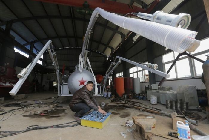 Чжан Вуй тестирует всасывающий трубопровод у своей новой подводной лодки, которая создана для того, чтобы собирать морские огурцы 