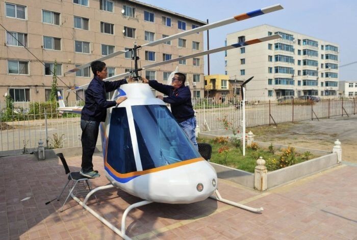 55-летний кузнец, Тиан Шенгиинг регулирует ротор своего самодельного вертолета