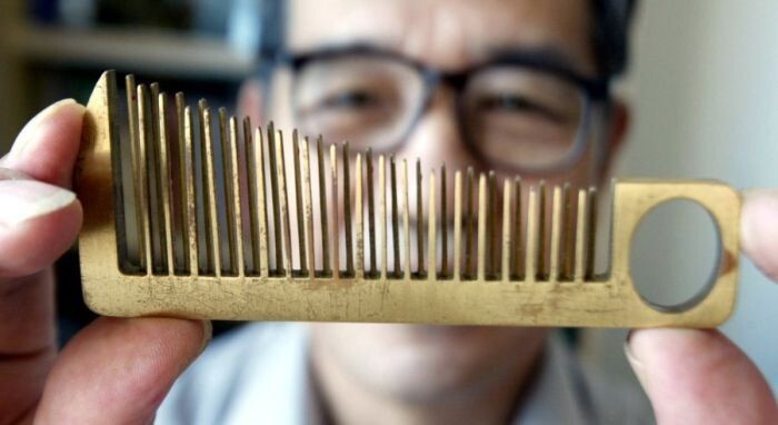 63-летний изобретатель Хан Йюзи демонстрирует не расческу, а новый музыкальный инструмент