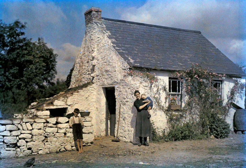 Семья стоит рядом со своим коттеджем в графстве Корк.
