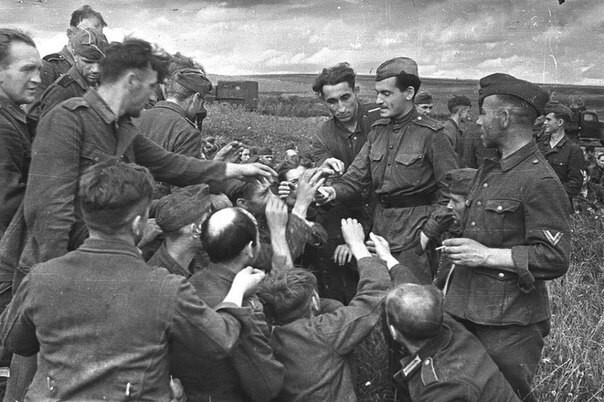 Советский солдат делится сигаретами с немецкими военнопленными. Вторая мировая, 1943 год.