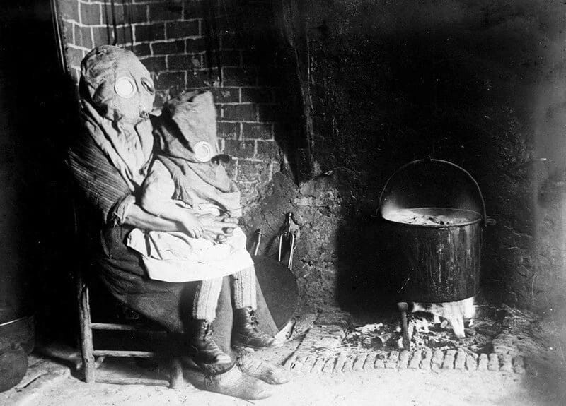 Мать с ребёнком готовят еду в противогазах. Французская глубинка, Первая мировая война.