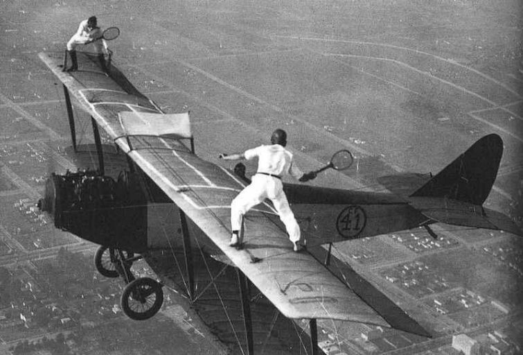Двое мужчин играют в теннис на крыльях би-плана, 1920 год